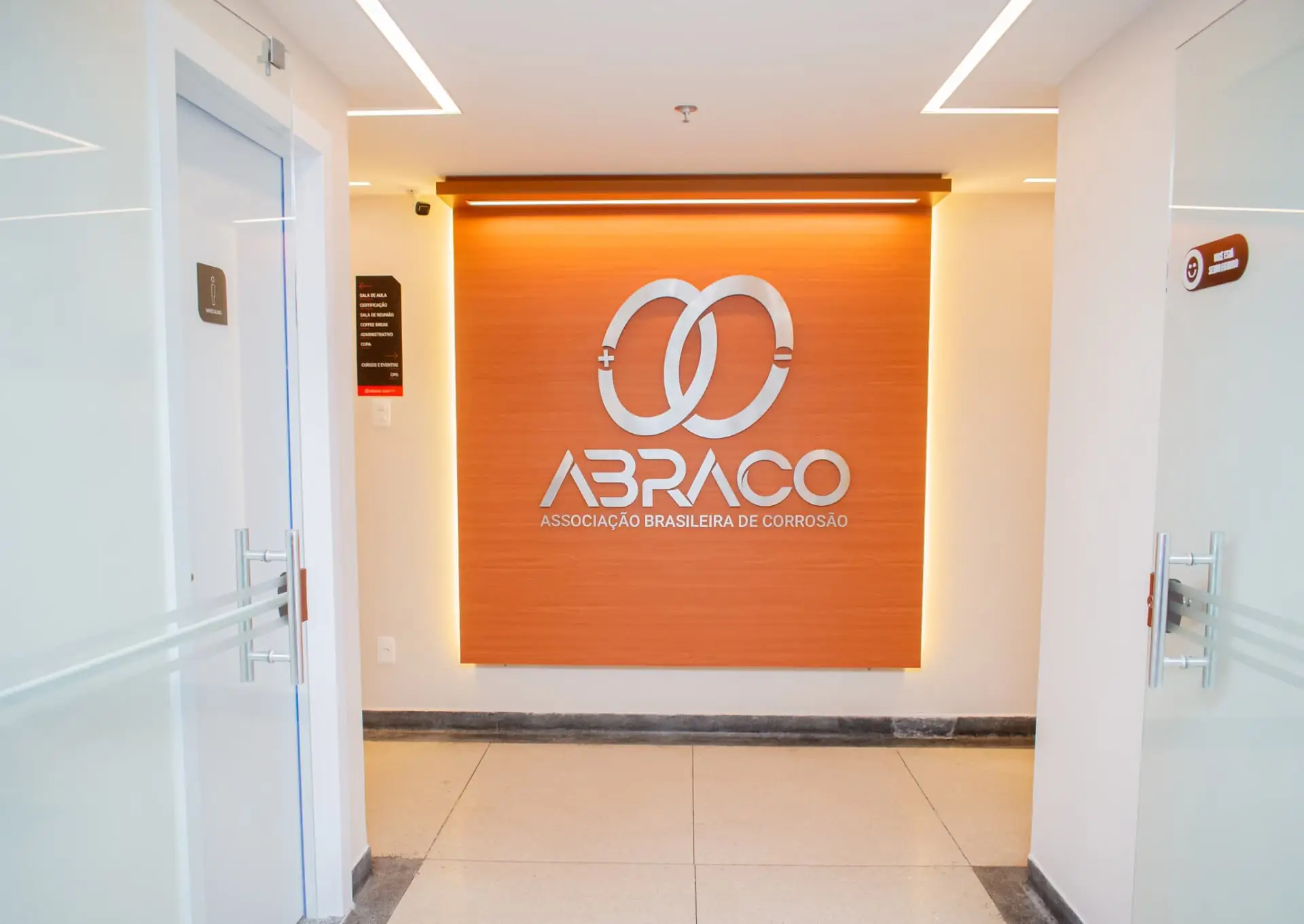 Entrada da ABRACO com painel de madeira e portas de vidro